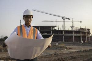 asiatischer ingenieur, der auf der baustelle eines großen bauprojekts arbeitet, thailänder, machen überstunden auf der baustelle foto