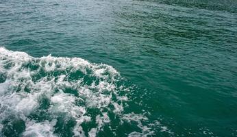 Meereswellen treffen das schöne smaragdgrüne Seeboot. foto