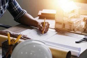 Bauingenieur, der an der Blaupause arbeitet, um große Geschäftsgebäude im Büro zu bauen. Engineering-Tools und Konstruktionskonzept. foto