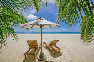 tropische Strandnatur als Sommerlandschaft mit Liegestühlen, Palmenblättern und ruhigem Meer für Strandbanner. luxusreiselandschaft, schönes ziel für urlaub oder urlaub. Strandszene