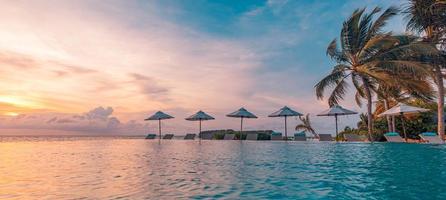 Outdoor-Luxus-Sonnenuntergang über Infinity-Pool Schwimmen Sommer Strandhotel Resort, tropische Landschaft. schöner ruhiger Strandurlaub Urlaub Hintergrund. erstaunliche insel sonnenuntergang strandblick, palmen foto
