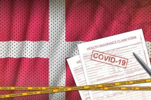 dänische flagge und krankenversicherungsantragsformular mit covid-19-stempel. Coronavirus- oder 2019-ncov-Viruskonzept