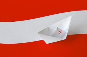 österreichische flagge auf papier origami schiff nahaufnahme dargestellt. handgemachtes kunstkonzept foto