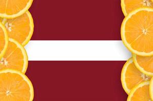 lettische flagge im vertikalen rahmen der zitrusfruchtscheiben foto