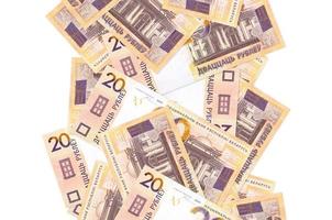 20 weißrussische Rubelscheine, die einzeln auf Weiß herunterfliegen. viele banknoten fallen mit weißem copyspace auf der linken und rechten seite foto