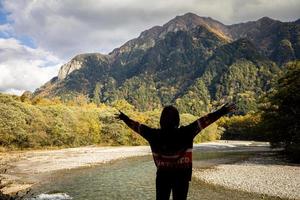 asiatische Mädchen mit einem schönen Hintergrund des Center Kamikochi National Park am Schneeberg, Felsen und Azusa-Fluss von der Hügeldecke mit Blattwechselfarbe während der Herbstlaubsaison. foto