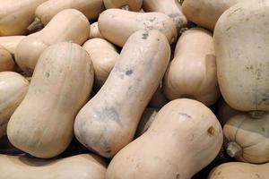 Stapel von Butternut-Kürbis auf einem Marktstand foto