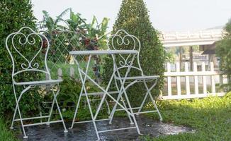 Garten-Wohnecke mit Tisch- und Stuhlgarnitur aus weißem Metall foto