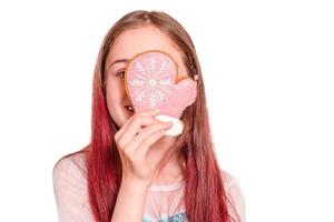 das mädchen lacht mit einem weihnachtslebkuchenhandschuh in ihren händen. Teenager-Mädchen, isoliert auf weiss. foto