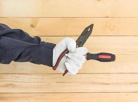 hand im handschuh mit schraubendreher und zange foto