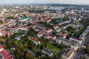 Luftpanorama aus großer Höhe einer kleinen grünen Provinzstadt mit Privatsektor und Wohnhochhäusern foto