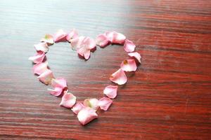 eine Herzform aus rosa Blütenblättern foto