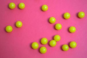 Gelbe runde medizinische Arzneimittel zur Behandlung von Krankheiten und zur Abtötung von Mikroben und Viren Pillen und Vitamine Medikamente gegen Coronavirus auf rosafarbenem Hintergrund foto