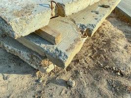 Betonplatte für den Bau von hohen, mehrstöckigen Gebäuden. rostige Beschläge auf der Platte, Befestigungen für die Verlegung von Fußböden. beschädigte Platten liegen auf dem Sand foto