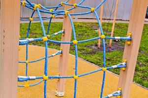 Neuer moderner sicherer Outdoor-Spielplatz im Freien mit Bewegungsgeräten und Spielzeug in einem neuen Stadtteil im Innenhof eines Neubaus foto