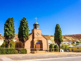 Alte Backsteinkirche mit Kirchturm und Doppeltüren in Bergbaustadt foto