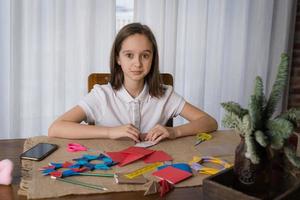 Ein wunderschönes Mädchen im Teenageralter macht Origami foto