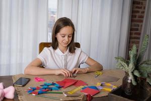 Ein wunderschönes Mädchen im Teenageralter macht Origami foto