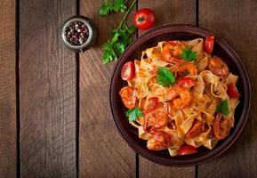 Fettuccine Nudeln mit Garnelen, Tomaten und Kräutern foto