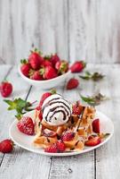 Belgische Waffeln mit Erdbeeren und Eis auf weißem Teller foto