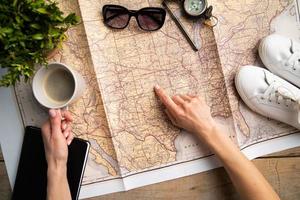 frauenhandzeichnung auf reisekarte, planungsreise oder urlaub