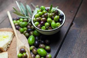 Olivenöl und Brot auf rustikalem Holztisch foto