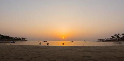 warme orange sonne bei sonnenaufgang mit schnorchlern am strand in ägypten panorama foto