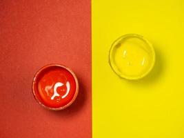 Gläser mit gelber und roter Farbe auf gelbem und rotem Hintergrund. Bank von Gouache. heller Hintergrund. Atelier des Künstlers. foto