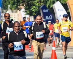 neu delhi, indien - 16. oktober 2022 - vedanta delhi halbmarathonrennen nach covid, bei dem die marathonteilnehmer kurz vor dem überqueren der ziellinie stehen, delhi halbmarathon 2022 foto