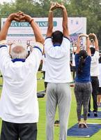 Gruppen-Yoga-Übungssitzung für Menschen verschiedener Altersgruppen im Cricket-Stadion in Delhi am internationalen Yoga-Tag, große Gruppe von Erwachsenen, die an Yoga-Sitzungen teilnehmen foto