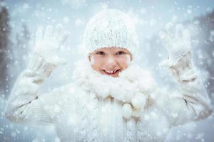 glückliches kleines Mädchen, das mit Schnee spielt foto