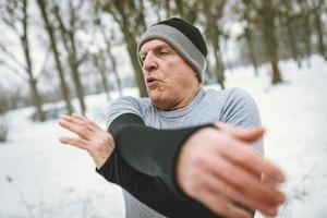 älterer mann, der sich nach dem joggen dehnt foto