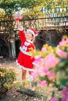 kleines asiatisches Mädchen im roten Weihnachtsmannkostüm foto