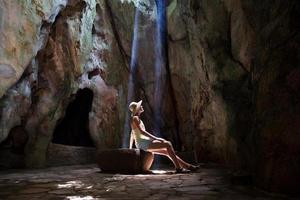 Mädchen in der Höhle unter Sonnenstrahlen foto