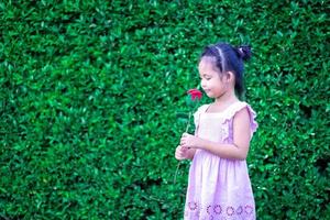 süßes kleines asiatisches Mädchen im Kleid im Park foto