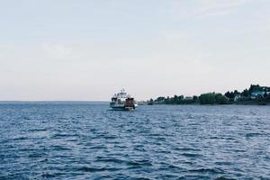 Boot im Ozean. einsames Boot am Horizont auf See. Seereise mit dem Boot. Ruhe am Meer. Fischerboot am Fluss. Handelsbeziehungen auf See foto