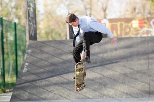 Geschäftsmann im Sprung mit Skateboard foto