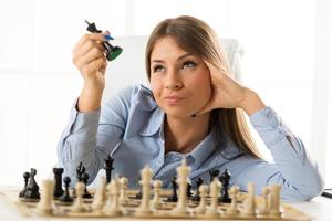 junge hübsche Geschäftsfrau mit Schachfiguren foto