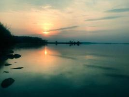 schöner roter sonnenuntergang über dem horizont des wassers im fluss, meer, ozean, see foto