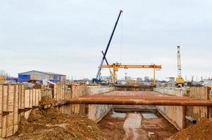 Ein großer Grabengrubentunnel mit Verstärkungskonstruktionen aus dicken Eisenrohren von Balken und Konstruktionen auf der Baustelle der U-Bahn-Stationslinie foto