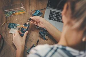 Ingenieurin testet Leiterplatte in ihrem Büro foto