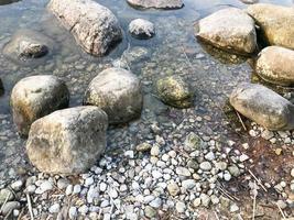 große runde schöne natursteine kopfsteinpflaster in wasser, meer, see, fluss. Hintergrund, Textur foto