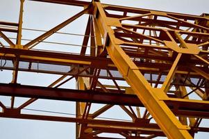 hohe, schwere, gelbe Metalleisen-Tragkonstruktion, stationärer, industrieller, leistungsstarker Portalkran vom Brückentyp auf Stützen zum Heben von Fracht auf einer modernen Baustelle von Gebäuden und Häusern foto