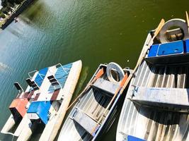 Boote und Katamarane auf einem Teichsee in einem Flusskanal mit grün blühendem Wasser sind am Ufer festgemacht foto