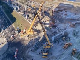 Bau einer neuen Überführung in der Innenstadt. Baumaterial auf Betonbrücke. Bau einer riesigen Brücke mit Maschinen foto