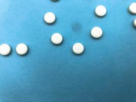 Runde medizinische Arzneimittel zur Behandlung von Krankheiten und zur Abtötung von Mikroben und Viren Pillen und Vitamine Arzneimittel gegen Coronavirus grau auf blauem Hintergrund foto