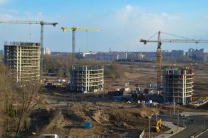 Draufsicht auf eine Großbaustelle mit Kränen und Gebäuden Häuser Beton monolithische Rahmenplatte mehrstöckige Wolkenkratzer der Großstadt der Metropole foto