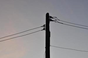 Silhouette Strommast und warmer Himmel. foto