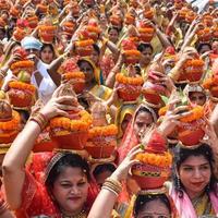 neu delhi, indien 03. april 2022 - frauen mit kalash auf dem kopf während des jagannath-tempels mangal kalash yatra, indische hindu-anhänger tragen irdene töpfe mit heiligem wasser mit einer kokosnuss darauf foto