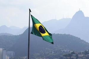 rio de janeiro, rj, brasilien, 2022 - brasilianische flagge mit christusstatue im hintergrund foto